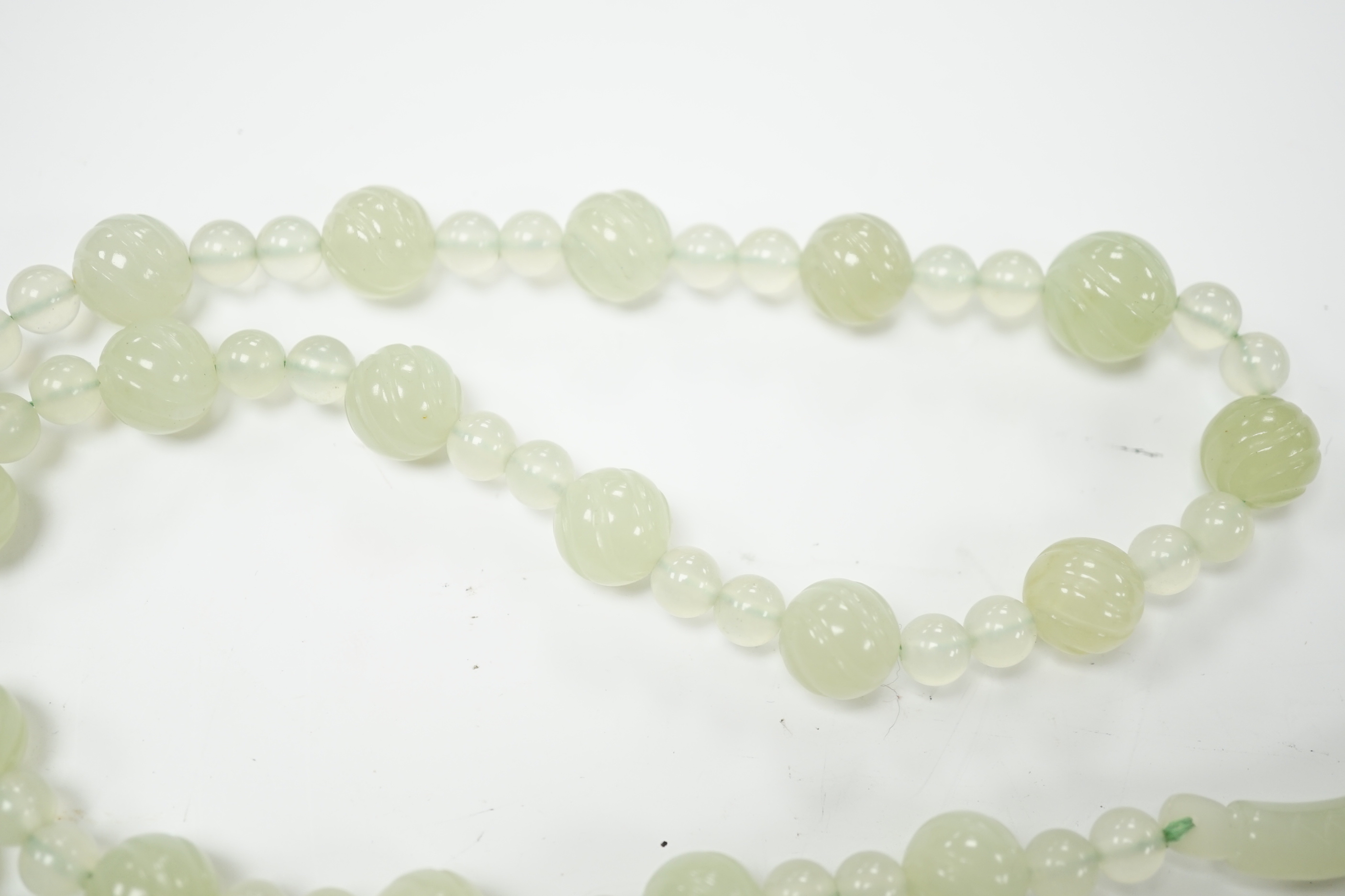 A bowenite jade bead necklace with dragon head clasp, circular pendant and carved disc